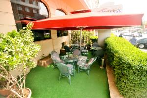 een patio met een tafel en stoelen en een parasol bij Topkapi Inter Istanbul Hotel in Istanbul