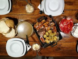 einen Tisch mit einem Tablett mit Lebensmitteln und Teller mit Lebensmitteln in der Unterkunft Golema Reka in Crni Vrh