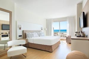 a bedroom with a bed and a view of the ocean at Melia Sitges in Sitges