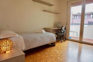 een slaapkamer met een bed, een bureau en een stoel bij appartamento benaco in Riva del Garda