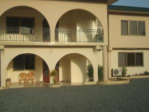 a building with arches and a balcony on top of it at Charis Home Services in Accra