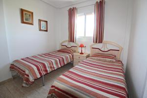 two beds in a small bedroom with a window at Veramar 6 in Vera +21 photos