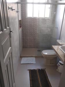 a bathroom with a toilet and a shower with a window at Recanto da Vovó com Bike in Vitória