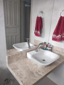 ein Badezimmer mit einem weißen Waschbecken und einem Spiegel in der Unterkunft Recanto da Vovó com Bike in Vitória