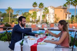 a man and woman sitting at a table with glasses of wine at Aldiana Club Costa del Sol in La Alcaidesa