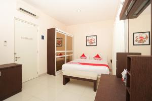 a bedroom with a bed with red pillows on it at SUPER OYO 782 Menjangan Residence at Citraland 1 in Lontar