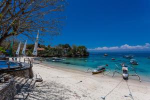 a sandy beach with boats in the water at Dream Beach Hostel Lembongan in Nusa Lembongan