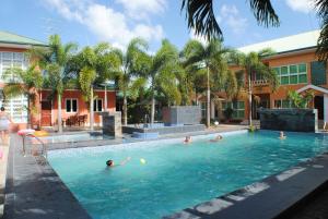 a group of people swimming in a swimming pool at Joah Inn Appartementen in Paramaribo
