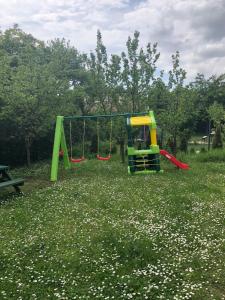 a playground with two swings in a field of flowers at Luxury Eagle apartman in Budapest