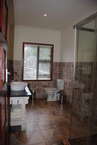 baño con 2 aseos y ducha acristalada en Golden Beach Village, en Ponta do Ouro