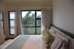 1 dormitorio con 1 cama y ventana grande en Golden Beach Village, en Ponta do Ouro