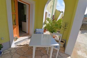a white table and two chairs in front of a house at Roberto 4 in Veli Lošinj