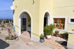a building with two arches and potted plants on it at Roberto 4 in Veli Lošinj