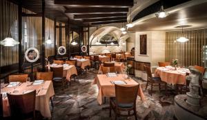 ريسيدينز ديلانغيلو في لوكارنو: مطعم فيه طاولات وكراسي في الغرفة