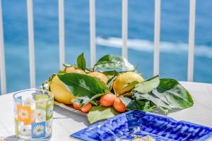 einen Obstteller auf einem Tisch mit einem Glas in der Unterkunft Edera in Amalfi