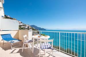 a balcony with a table and chairs overlooking the ocean at Edera in Amalfi
