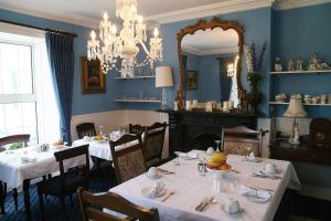 una sala da pranzo con 2 tavoli e uno specchio di Muxnaw Lodge a Kenmare