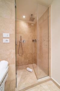 baño con ducha y puerta de cristal en Rooms Milano Duomo, en Milán