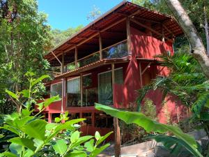 una casa roja en medio de un bosque en Casa Rossa Bungalows & Apartments, en Morro de São Paulo