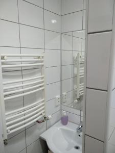 a white bathroom with a sink and a mirror at Casa Sforii Brasov in Braşov