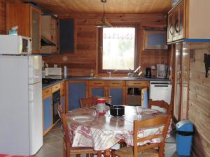 eine kleine Küche mit einem Tisch und einem Kühlschrank in der Unterkunft Gîte le Clapier in Theys