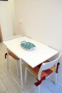 d'une table et d'une chaise blanches avec une plaque. dans l'établissement Renovated Central Suites, à Florence