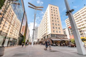 a group of people walking down a street in a city at Apartments Golden Warsaw by Noclegi Renters in Warsaw +32 photos