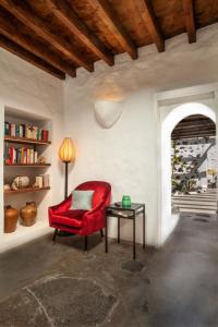 una silla roja sentada en una habitación con una mesa en Los Lirios Hotel Rural - Adults Only, en Tías