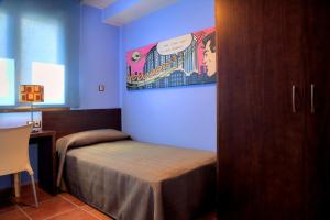 1 dormitorio con 1 cama y una pintura en la pared en Apartamento La Seo, en Barbastro
