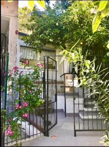 ナポリにあるGARDEN HOUSE Apartments in Naplesの建物前の花の黒い鉄門