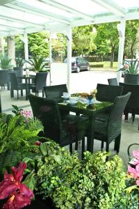 um pátio com uma mesa, cadeiras e flores em Hotel Vernel em Rimini