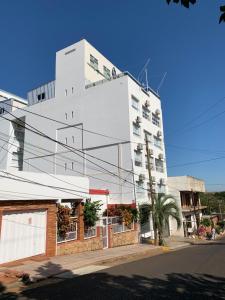 un edificio blanco alto en una calle de la ciudad en Departamento Rodrigo II en Posadas