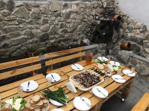 einem Holztisch mit Teller mit Lebensmitteln darauf in der Unterkunft Light House Old City in Achalziche