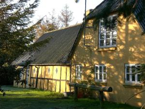 a yellow house with a shadow on the side of it at Fædrelandet Ferielejlighed & Turridning in Læsø