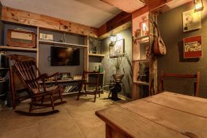 Una sala de estar con sillas, una mesa y un televisor. en Mango Rooms, en Brasov