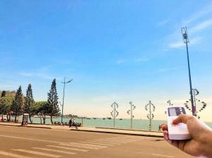 a person taking a picture of the water with a cell phone at SWEET HOME in Vung Tau