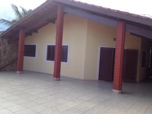una casa con due colonne di mattoni rossi di Casa com Piscina a Itanhaém