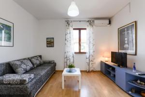 - un salon avec un canapé et une télévision dans l'établissement Apartments Marija, à Bibinje