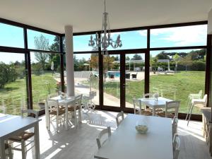 聶圖諾的住宿－PepeRosa B&B and Events，一间设有大窗户和白色桌椅的用餐室