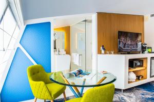 ボルドーにあるSeeko'o Hotel Bordeauxのガラステーブルと椅子2脚が備わる客室です。
