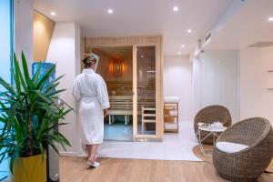 a woman in a white robe standing in a room at Seeko'o Hotel Bordeaux in Bordeaux