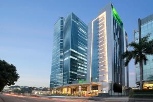 a large tall building with a shopping center in front of it at ibis Styles Jakarta Tanah Abang in Jakarta