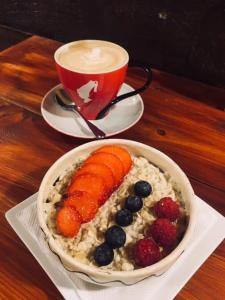 a bowl of oatmeal with fruit and a cup of coffee at Travelodge Dublin City Rathmines in Dublin