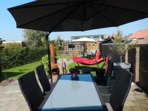 a table and chairs with an umbrella on a patio at B&B De Passant in Breskens +24 photos