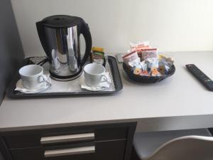 a coffee maker and cups on a desk at ROMA ROOMS in Ancona