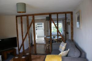 a living room with a couch and a table at Wayside Cottage in Saint Osyth