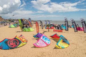 a beach with many colorful kites on the sand at Wayside Cottage in Saint Osyth