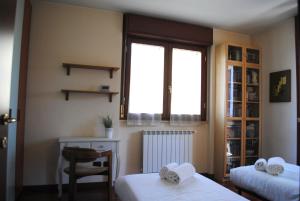1 dormitorio con 2 camas, ventana y silla en Bnbook - Volta Fiera Milano, en Rho
