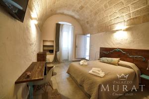 a bedroom with a bed and a table in a room at Palazzo Murat B&B in Monopoli