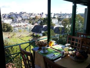 a table with a view of a city from a balcony at Cit'Hotel Du Port Rhu in Douarnenez